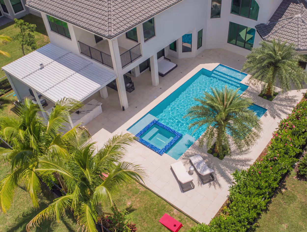 Modern luxury custom pool in South Florida featuring integrated spa, clean architectural lines, and high-end outdoor living design for upscale homes.