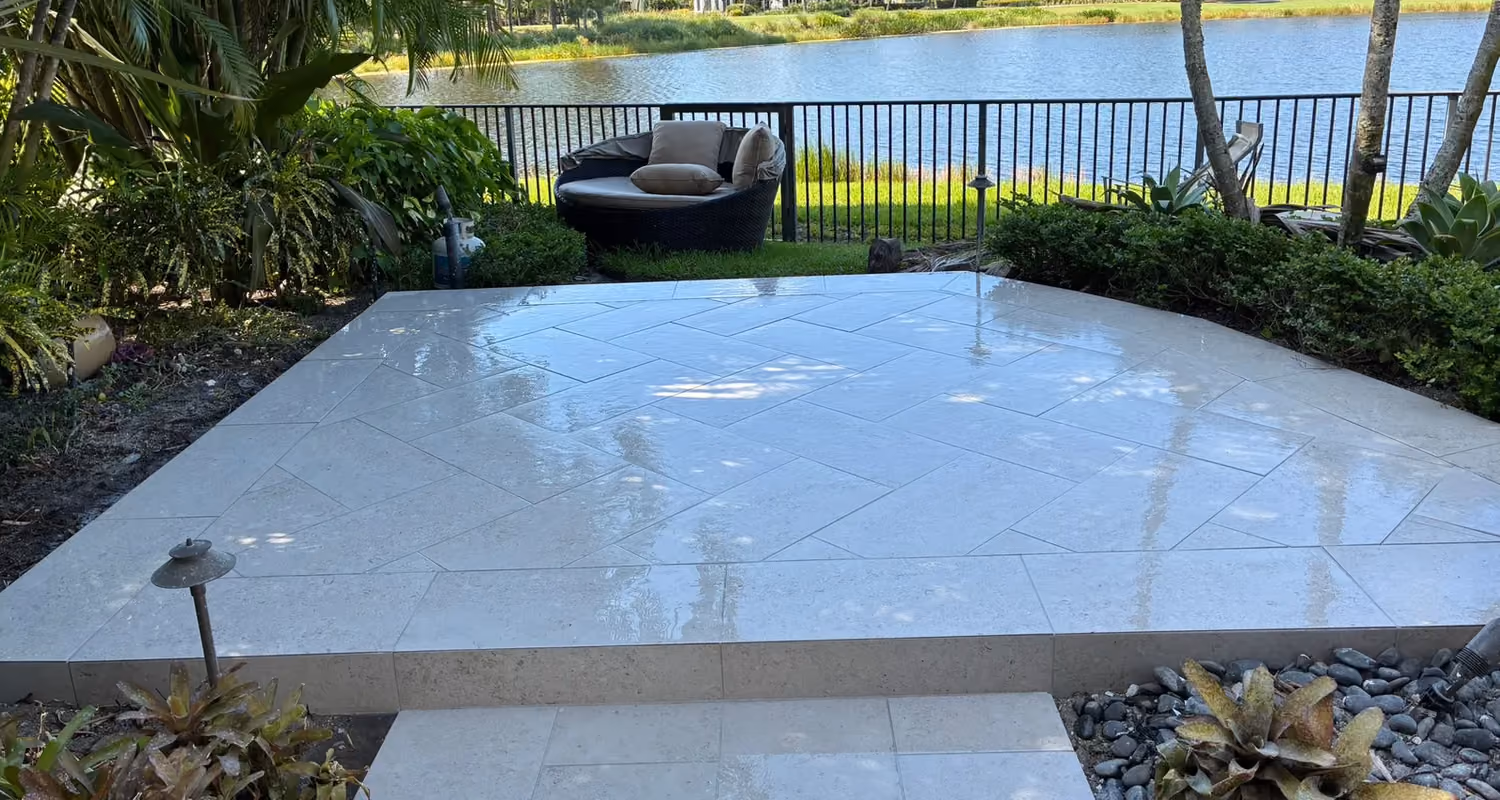 Raised limestone paver patio in a herringbone layout overlooking a lake and golf course.